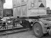 837842 Afbeelding van het overzetten van een autolaadkist van vrachtwagen naar spoor op het terrein van Van Gend & Loos ...